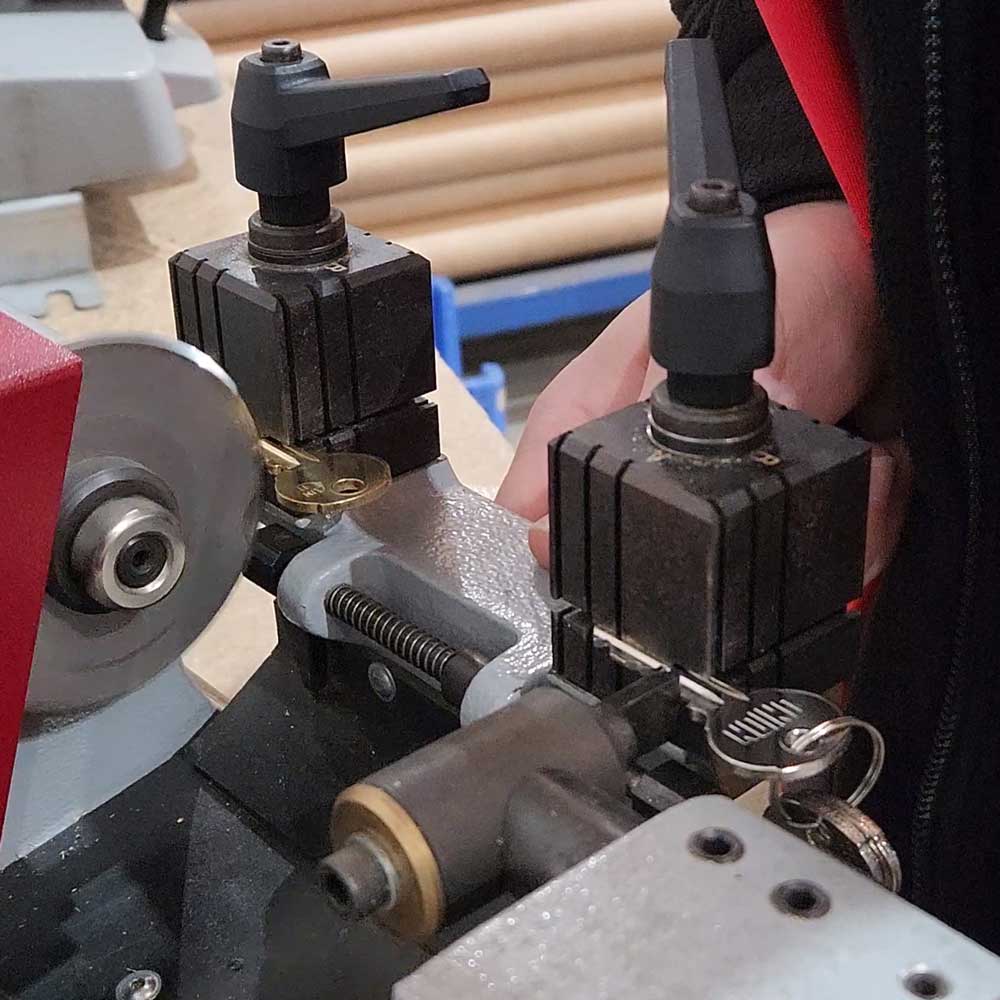 Locksmith cutting key blank with key cutting machine